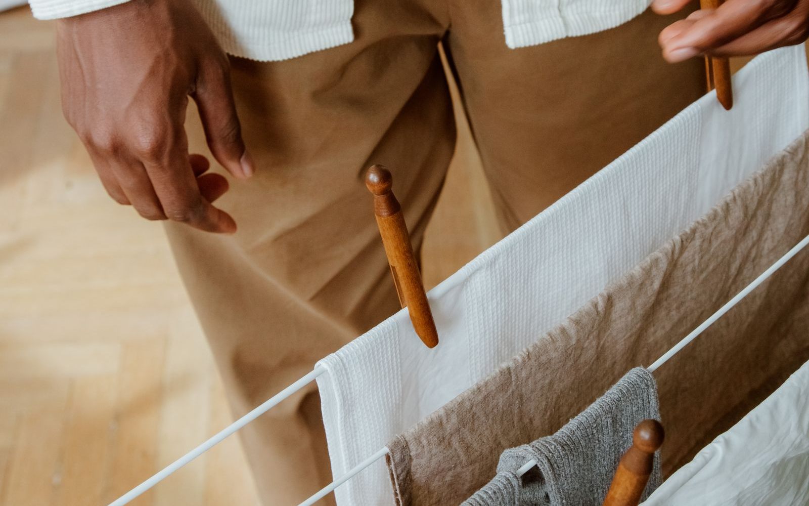 Hanging clothes to air dry on a white drying rack with wooden clothespins