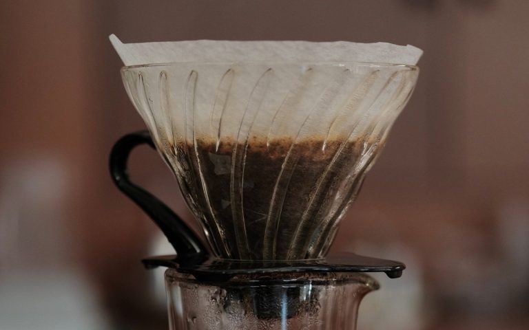 Coffee brewing through a paper filter in a glass pour-over dripper